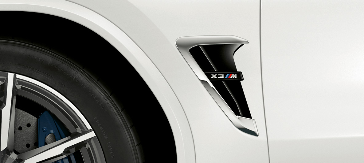 BMW X3 M, M kopoltyú. Alpesi fehér BMW X3 M, külső, M kopoltyú krómozott elemekkel és típusfelirattal.