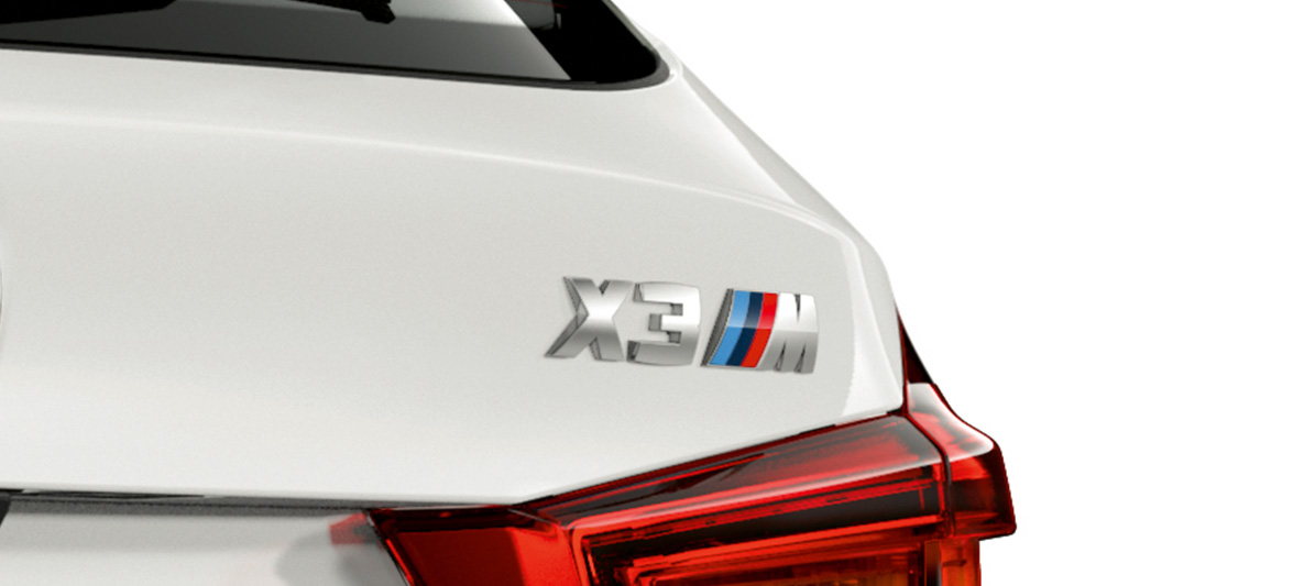 BMW X3 M, típusfelirat. Alpesi fehér BMW X3 M, kívülről, far a típusfelirattal.