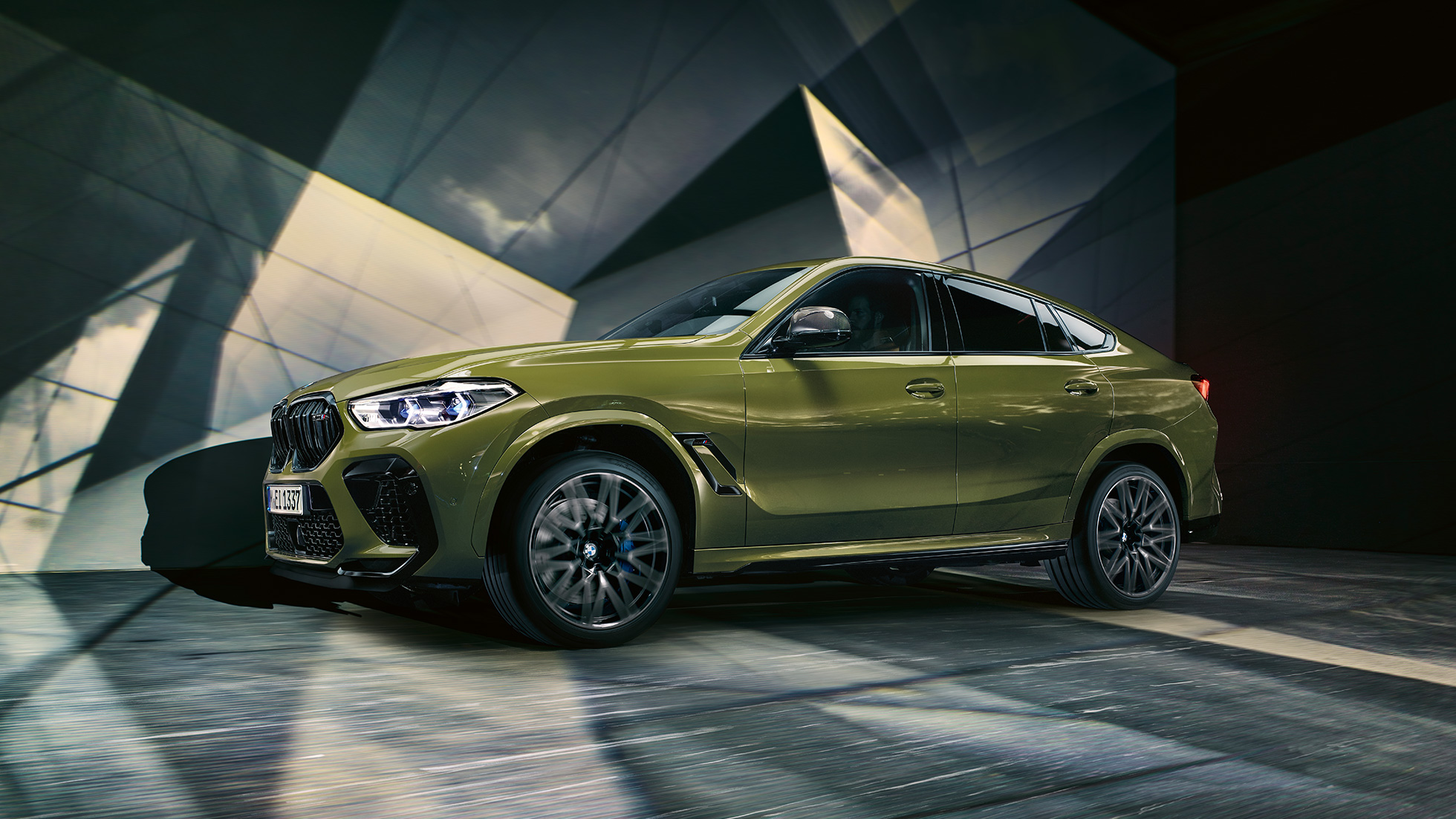 BMW X6 M Competition, oldalnézet Egy BMW X6 M Competition M könnyűfém keréktárcsákkal, F96, BMW Individual Urban zöld speciális fényezés, oldalnézet