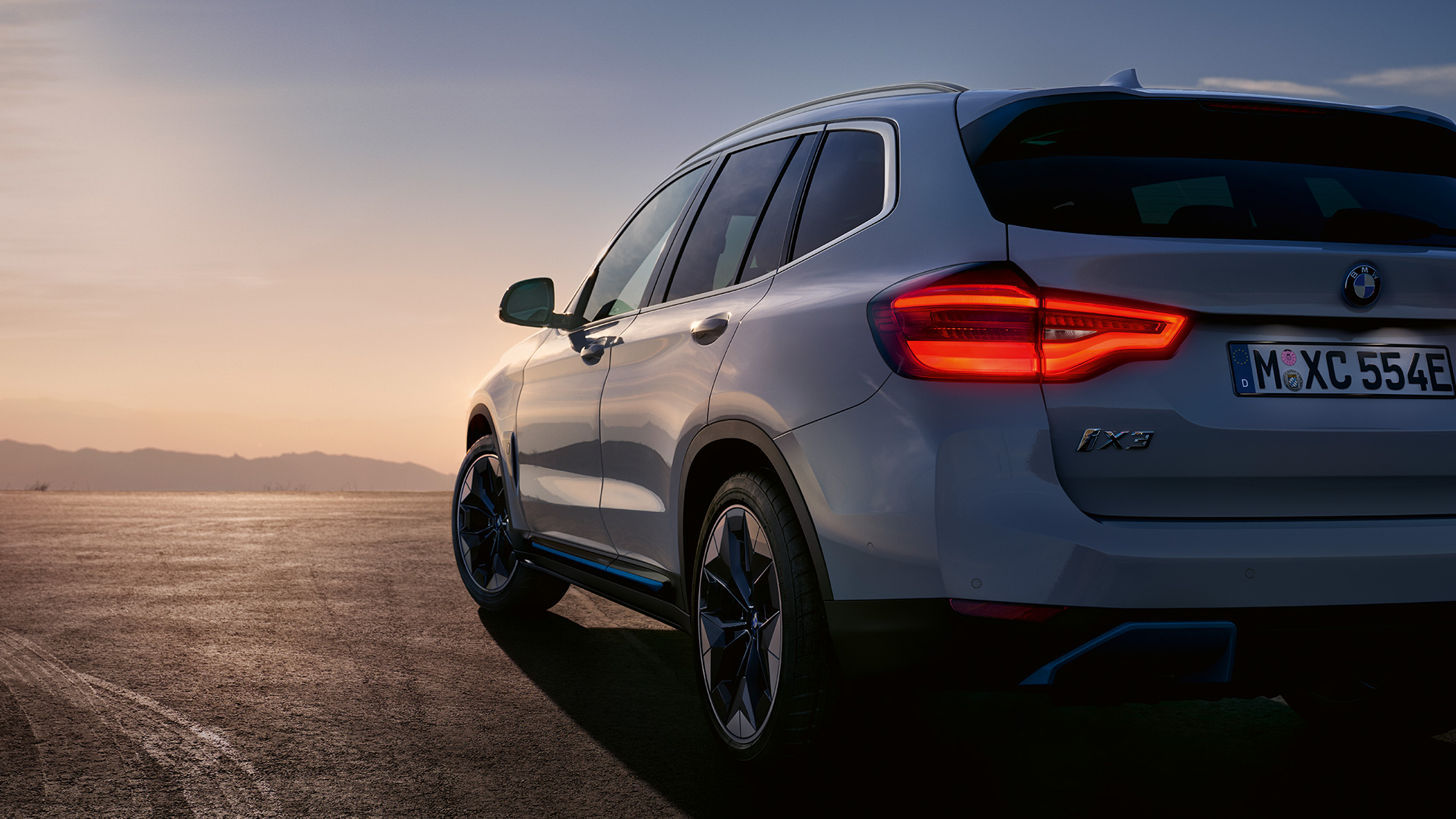 BMW iX3, G08, egy mozgó autó rézsútos hátulnézetből BMW iX3, G08, 2020, egy mozgó, Kristály fehér metálfényezésű autó rézsútos hátulnézetből