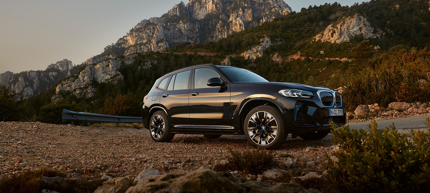 BMW iX3, G08, egy M Karbonfekete autó oldalnézetből