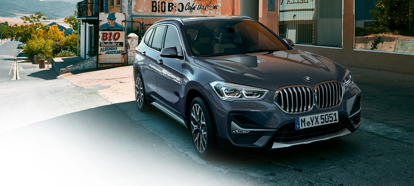 BMW X1, háromnegyedes elölnézet. BMW X1, az álló autó háromnegyedes elölnézetből, városi környezetben.
