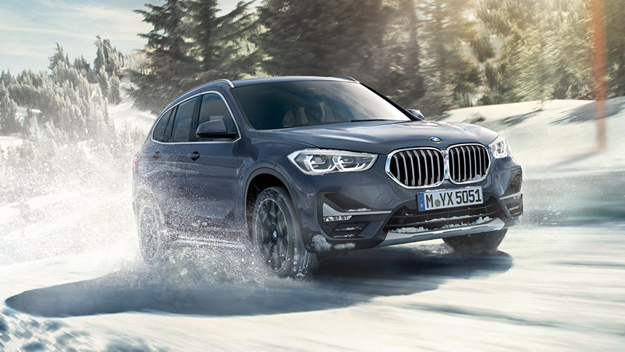 BMW X1 xDrive20i, F48 LCI, egy téli tájon haladó, BMW Individual Storm Bay metálfényezésű autó BMW X1 xDrive20i, F48 LCI, egy téli tájon haladó, BMW Individual Storm Bay metálfényezésű autó