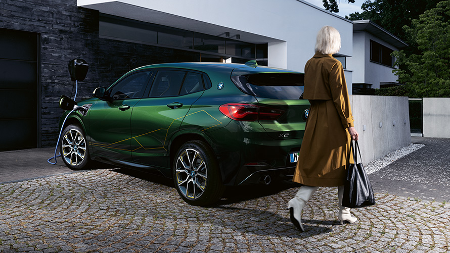 BMW X2 F39 Sanremo Green metallic Three-quarter rear view with model BMW X2 F39 Sanremo Green metallic Three-quarter rear view with model