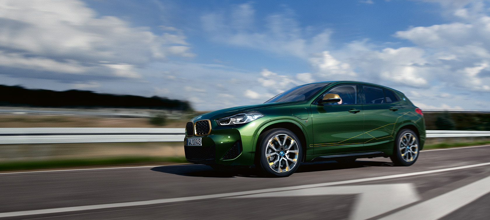 Egy mozgó autó rézsútos oldalnézetből, BMW X2, F39, Sanremo zöld metál