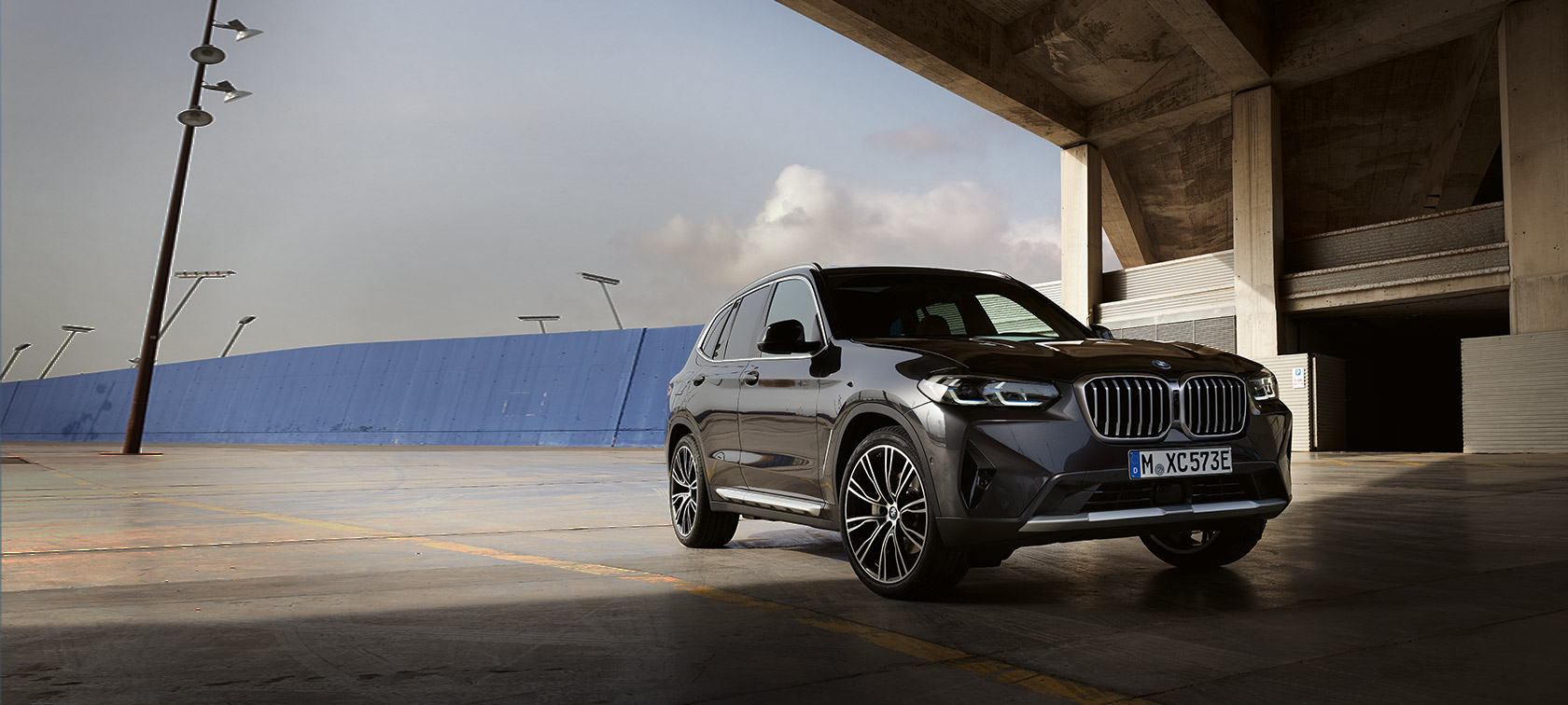 BMW X3, G01, egy hangár előtt álló, Sophisto szürke autó rézsútos elölnézetből, 2021