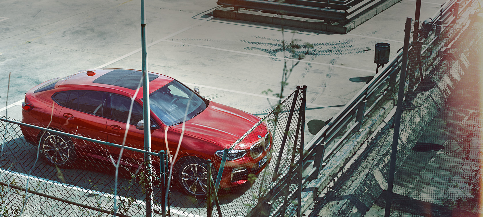 Parkoló BMW X4 BMW X4, G02, 2018, Flamenco vörös briliáns hatással, egy parkolóhelyen álló autó felülről