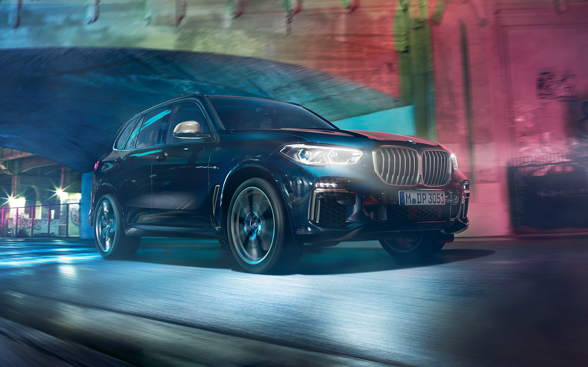 A BMW X5 M50d mozgás közben Felvétel az éjszaka, városi környezetben haladó BMW X5 M50d-ről