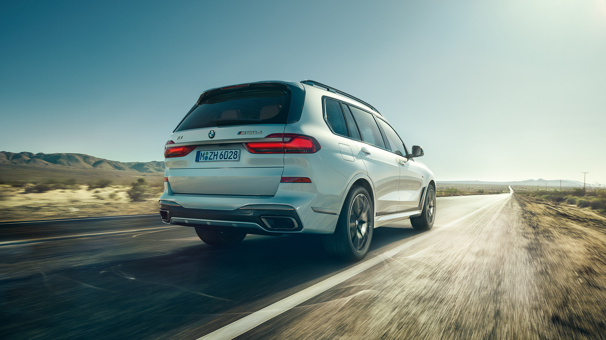 BMW X7 M50d, hátulnézet BMW X7 M50d: egy haladó, fehér színű BMW X7 hátulról