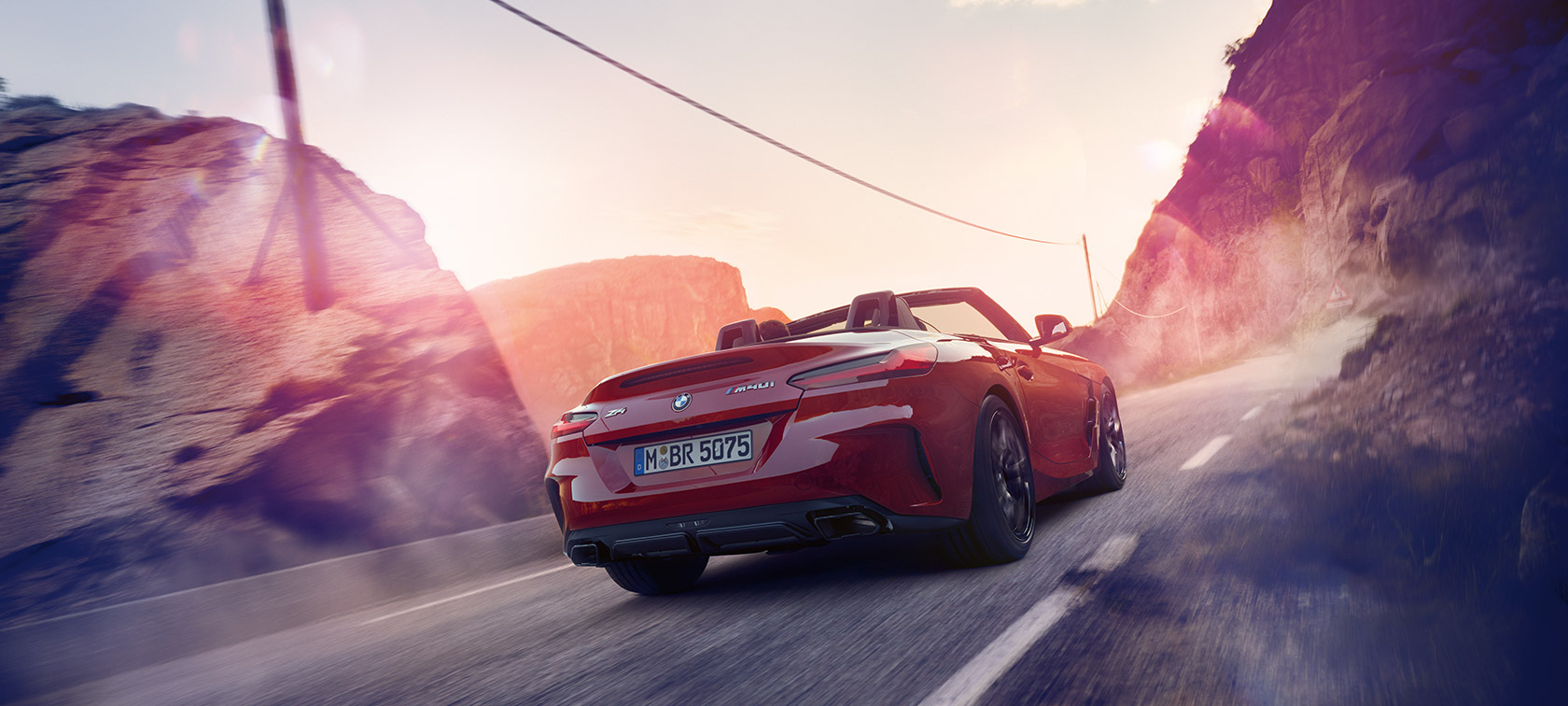 Egy BMW Z4 Roadster hegyvidéki tájon halad Egy BMW Z4 Roadster hegyvidéki tájon halad