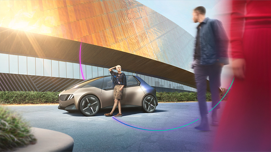 2050-re megvalósítandó célkitűzések, BMW Speciális Értékesítés, Fenntarthatóság, Áttekintés BMW Speciális Értékesítés, Fenntarthatóság, Áttekintés, 2050-re megvalósítandó célkitűzések, egy nő és egy férfi áll egy BMW tanulmányautó előtt