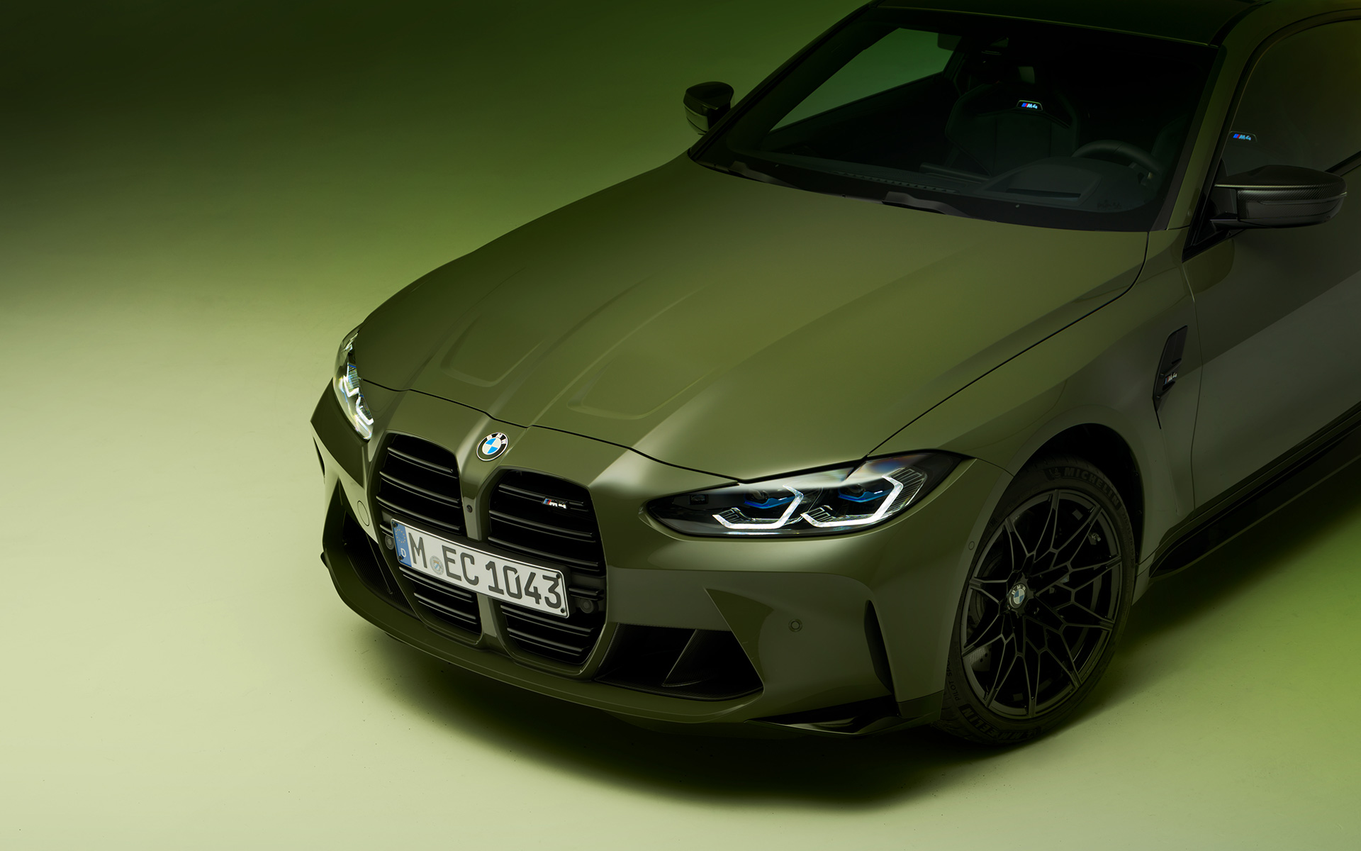 BMW M4 Competition Coupé, G82, 2021, BMW Individual Urban zöld, rézsútos elölnézet BMW M4 Competition Coupé, G82, 2021, egy BMW Individual Urban zöld autó rézsútos felső elölnézetből, részletfotó