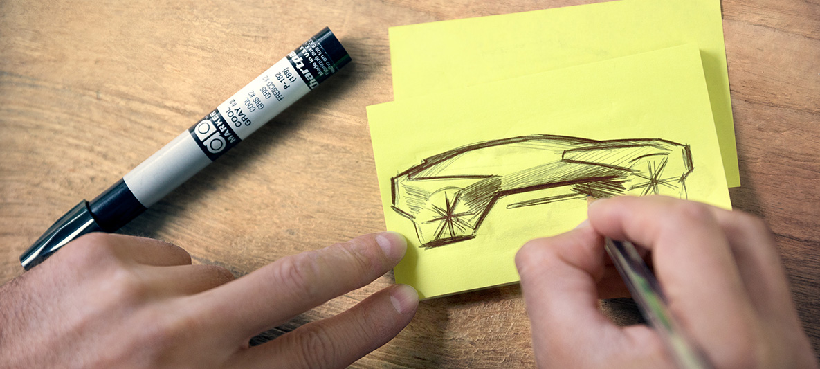 A BMW Vision iNEXT skicce Kezek a BMW Vision iNEXT-et ábrázoló skicceket vázolnak egy post-itre