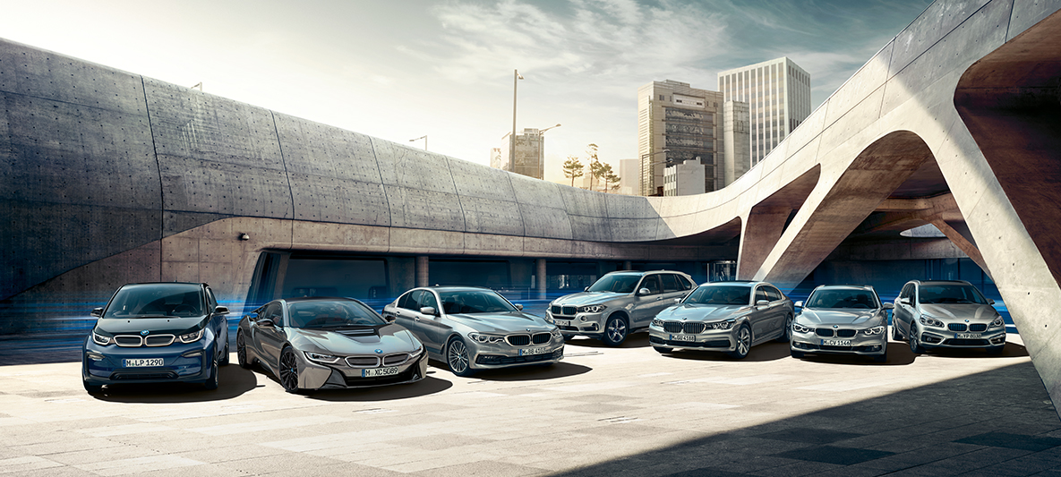 BMW elektromos autók és hibrid járművek épületek előtt BMW elektromobilitás, lehetőségek, BMW elektromos autók és hibrid járművek épületek előtt
