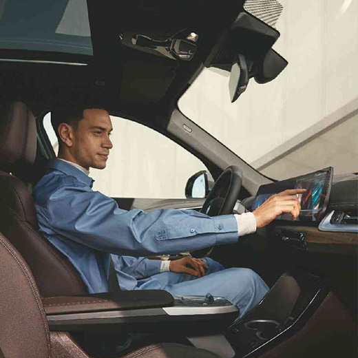 Connected Charging egy BMW fedélzetén, egy férfi a BMW Curved Display kijelzőt használja