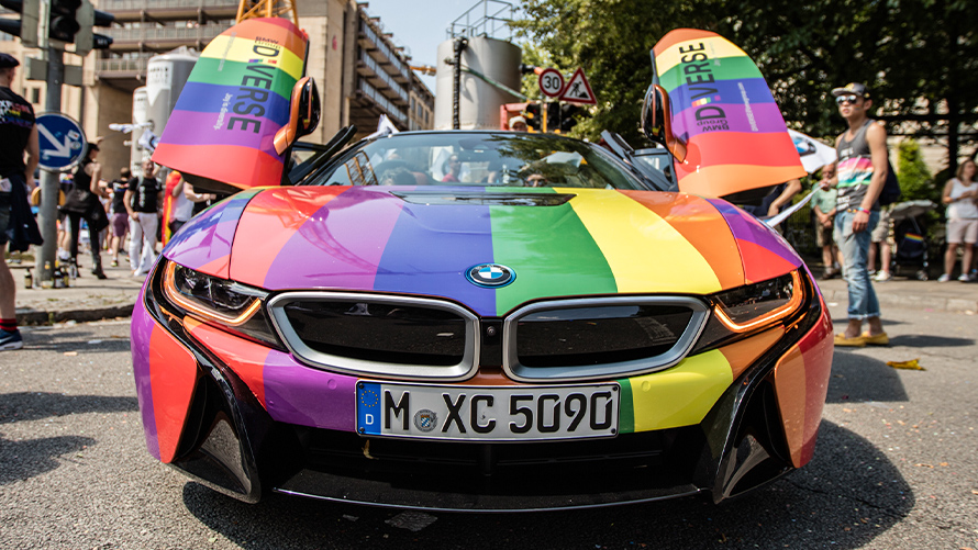 Sokszínűség, BMW Fenntarthatóság BMW Fenntarthatóság, sokszínűség, egy szivárványszínű BMW jármű elölnézetből, nyitott sirályszárnyas ajtókkal
