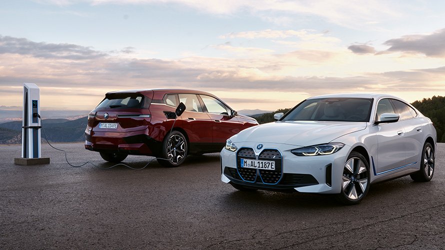 BMW BEV, sokoldalú, BMW Fenntarthatóság BMW Fenntarthatóság, BMW BEV választék, két BMW jármű áll egy töltőállomáson
