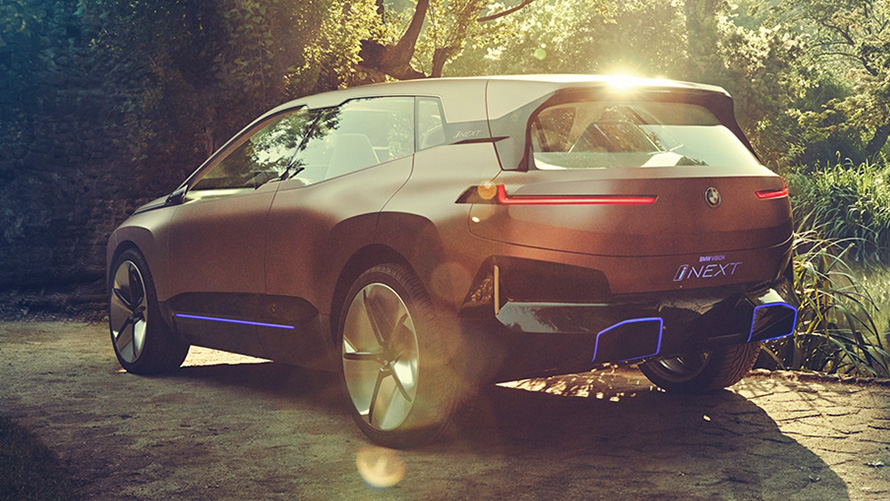 A BMW Vision iNEXT egy erdővel a háttérben A BMW Vision iNEXT egy erdővel a háttérben, rézsútos elölnézetből