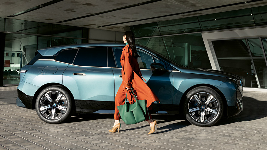 BMW Digitális kulcs, előnyök BMW Digitális kulcs, előnyök, BMW iX i20, oldalnézet egy nővel az előtérben