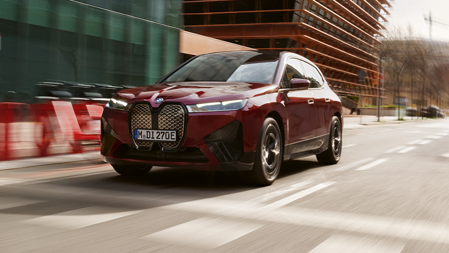 Személyreszabhatóság, BMW Digitális kulcs, BMW iX i20 BMW Digitális kulcs, személyreszabhatóság, BMW iX i20, egy úton haladó autó rézsútos elölnézetből