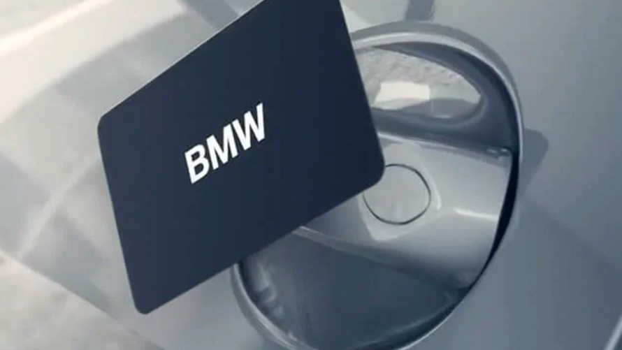BMW kulcskártya Egy férfi a BMW kulcskártya segítségével nyitja a BMW-jét.