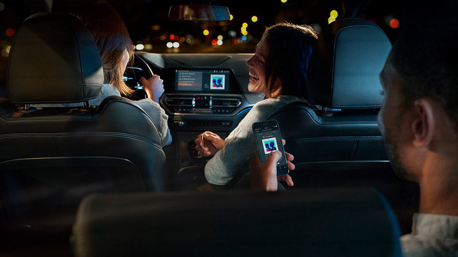 Connected Command Connected Command: Három, a BMW-ben helyet foglaló személy zenét játszik le utazás közben