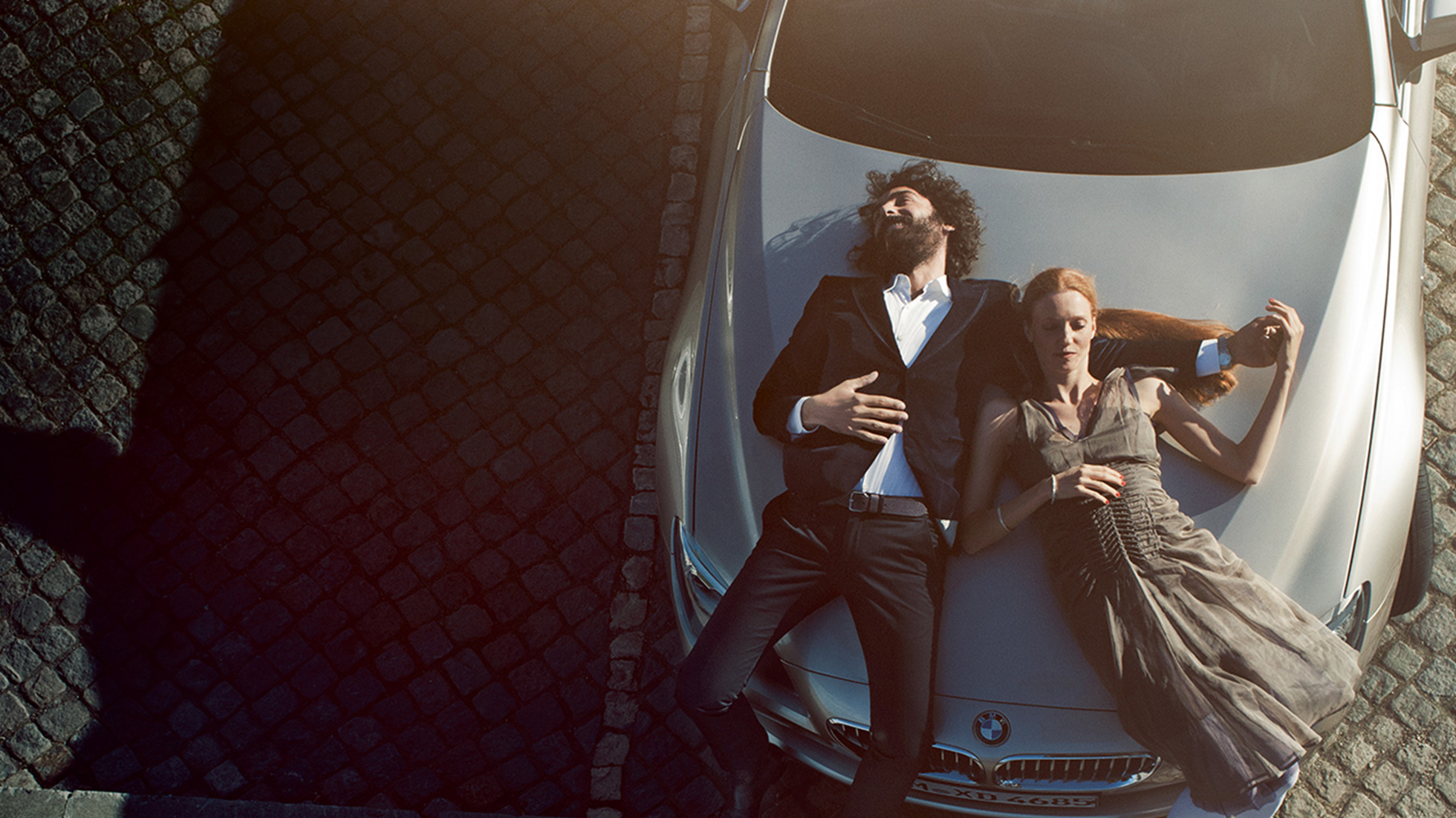 BMW Service, eredeti BMW motorolaj BMW Service, eredeti BMW motorolaj, egy férfi és egy nő fekszik önfeledten egy BMW motorháztetőjén