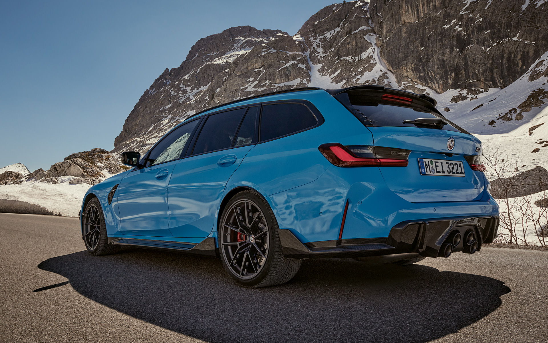 BMW M3 Touring, G81, BMW M Performance tartozékok, egy mozgó rézsútos oldalnézetből BMW M3 Touring, G81, BMW M Performance tartozékok, egy hegyi tájon haladó autó rézsútos oldalnézetből