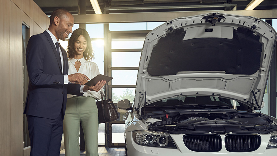Átvizsgálás és karbantartás Egy BMW Service ügyfél és a BMW márkaszerviz alkalmazottjai az átvizsgálásról és a karbantartásról beszélgetnek