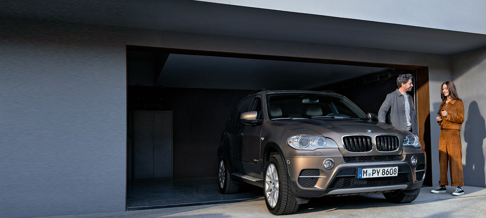 BMW Szerviz 5+ BMW Szerviz 5+, egy férfi és egy nő egy garázs előtt, amelyben egy BMW X5 áll