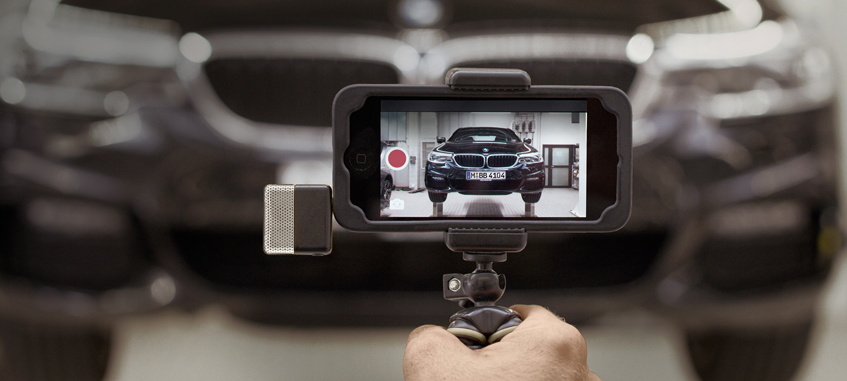 BMW Service videó egy okostelefonon A BMW Service videó fut egy okostelefonon egy BMW előtt