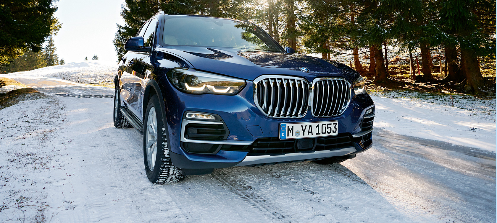 BMW őszi és téli tartozékok Egy havas úton haladó BMW X3 rézsútos elölnézetből